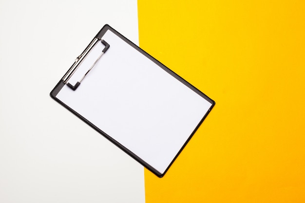 Blank clipboard paper on bright yellow 