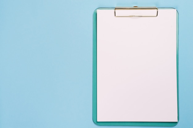 Blank clipboard on pastel blue color background with copy space, flat lay