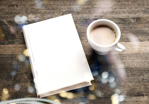 Blank closed booklet, pencil and coffee cup on vintage wood background. Responsive design mockup.