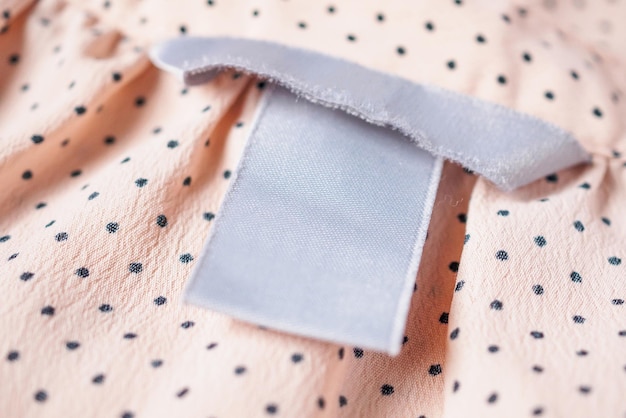 Primo piano dell'etichetta di abbigliamento in bianco sulla struttura del tessuto