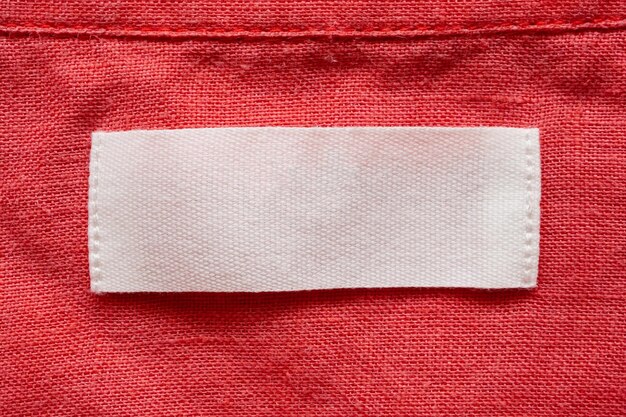 Blank clothing tag label on linen shirt fabric texture background