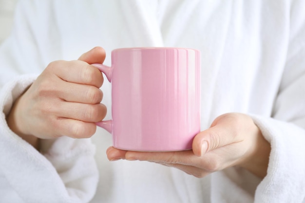 Blank color cup in hands closeup