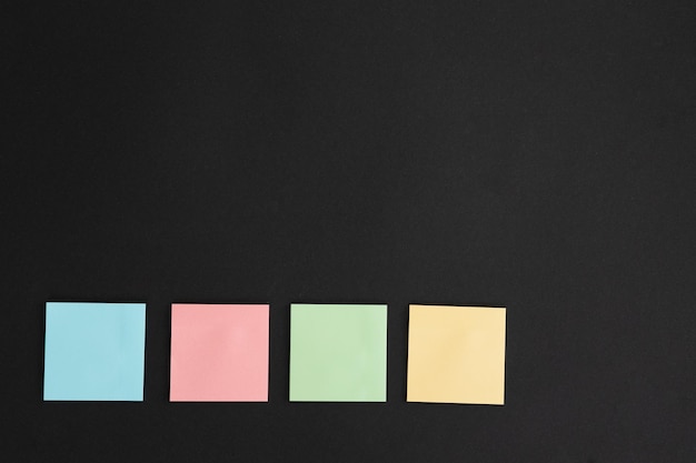 Blank colorful sticky notes on black background