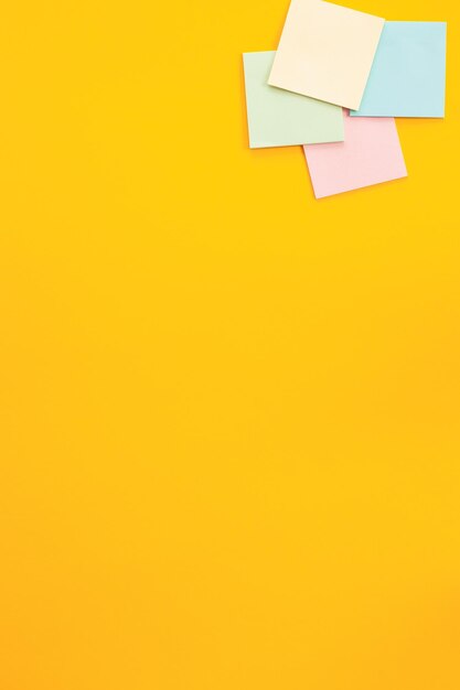 Blank colorful sticky notes on yellow background flat lay