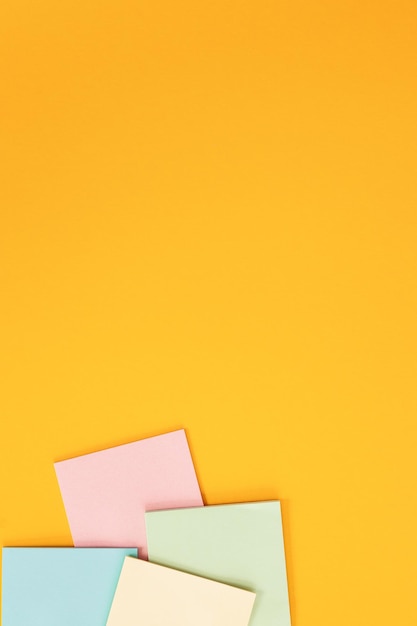 Blank colorful sticky notes on yellow background flat lay