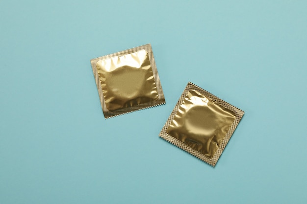 Blank condoms on light blue surface