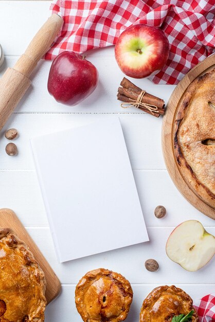 Фото Пустой макет обложки кулинарной книги с яблочным пирогом, мясным пирогом и сезонными фруктами