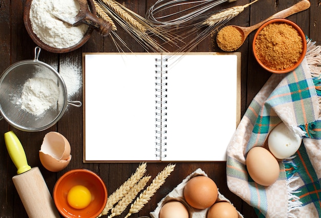 Libro di cucina in bianco, ingredienti e utensili vista dall'alto