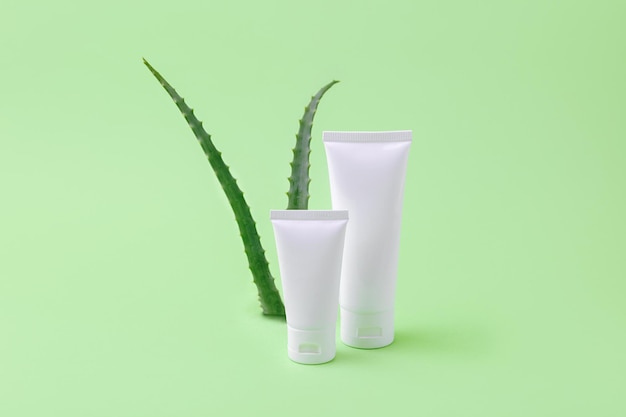 Blank cosmetics tubes with aloe vera on backgroundOrganic cosmetic concept