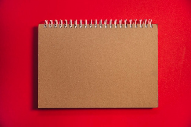 Blank craft notepad op een rode achtergrond feestelijke kerstmis en nieuwjaar minimalistisch frame met kopieerruimte voor tekst