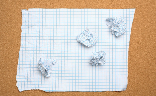 Blank crumpled white sheet of paper in a cage and crumpled balls, top view