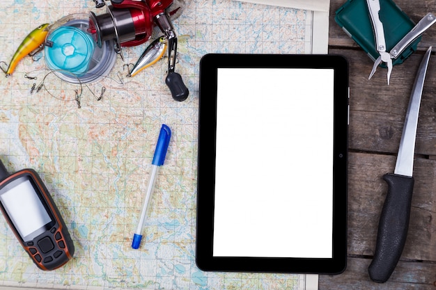 Blank digital tablet with fishing tackles and navigator on map