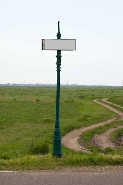 遠くに伸びる道を背景にした空白の方向標識