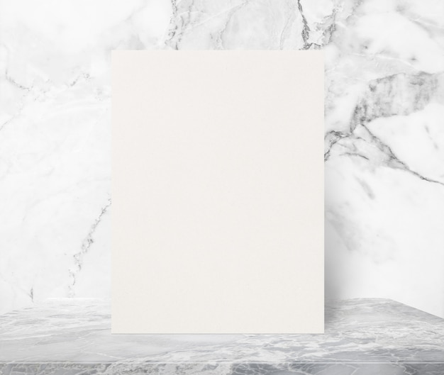白い大理石の壁の背景で大理石の石のテーブルの上に空白のエコテクスチャ紙のポスター。