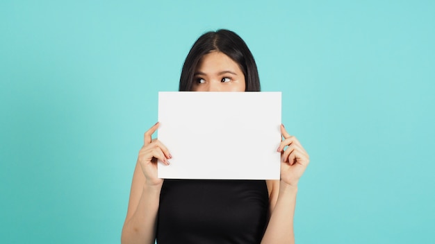 Blank empty paper in asian woman's hand on mint green or Tiffany Blue background.