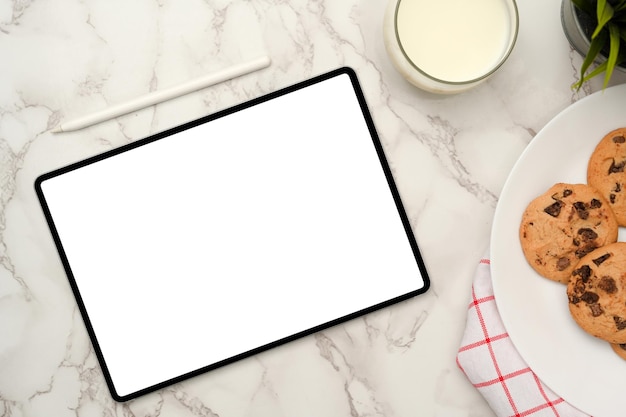 Blank empty white screen tablet touchpad mockup with a plate of cookies and a glass of milk