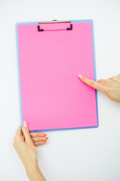 Пустая папка с розовой бумагой, рука, которая держит папку и ручка на белом