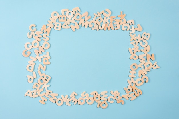 Photo blank frame made with wooden alphabets on blue background