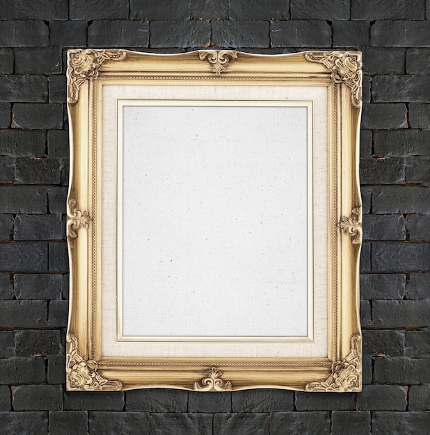 Photo blank gold color vintage photo frame hanging on black brick wall,template for adding your photo