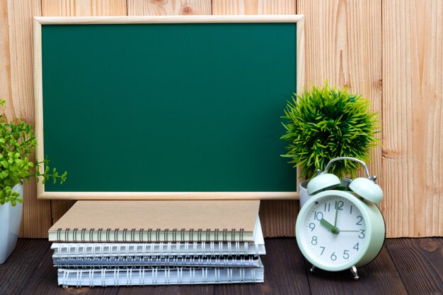 Blank green chalkboard and little tree with vintage alarm clock