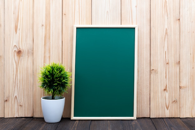空白の緑の黒板と木の小さな木