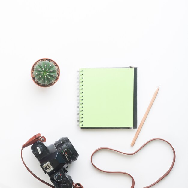 Photo blank green color notebook and camera on white background, summer lifestyle concept