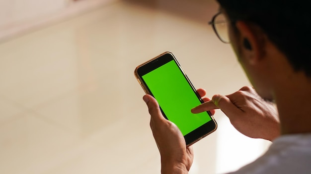 blank green screen mockup of mobile phone man hand pointing to screen education technology