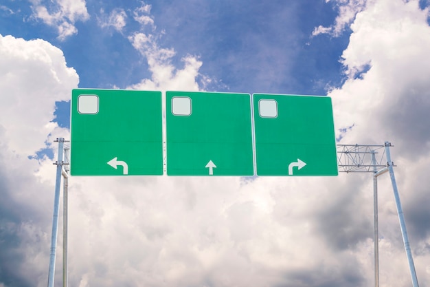 空と雲の背景の空白の緑の交通道路標識