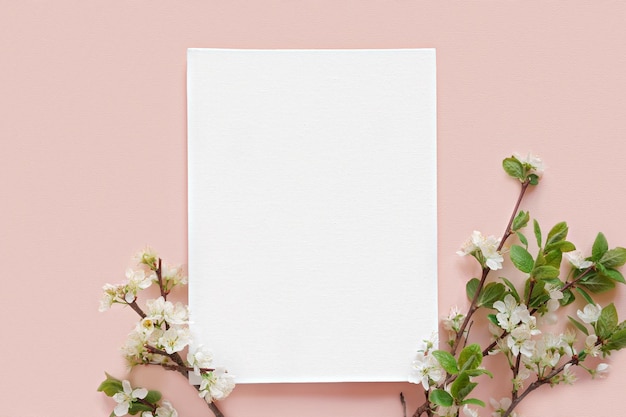 Foto mockup di invito biglietto di auguri vuoto fiori di mela sbocciare pianta su sfondo rosa tavolo vista dall'alto laico piatto copyspace tela mock up modello di marchio aziendale moderno minimal ombra morbida