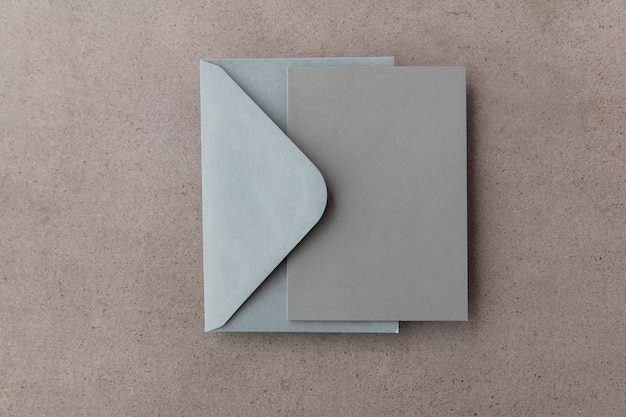 Photo blank grey card with grey paper envelope template mock up on a concrete background