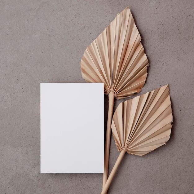 Photo blank invitation card for a natural wedding or celebration event with dried palm leaf stem