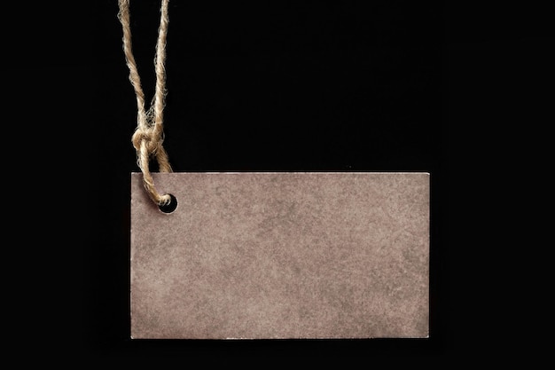 Blank label on a black background cardboard tag tied to the product with a rope shows the price