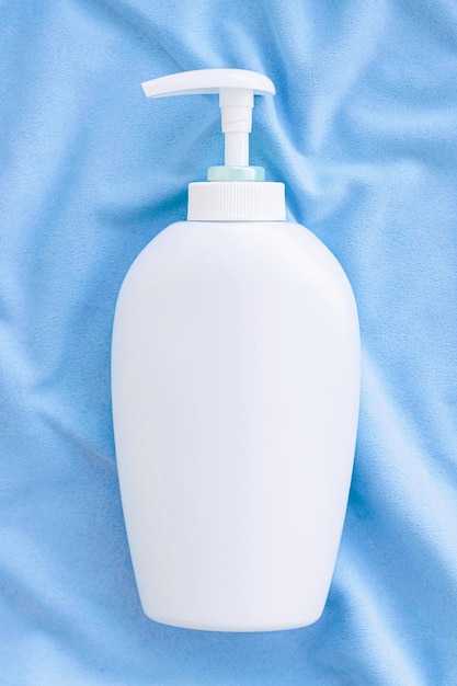 Blank label bottle of antibacterial liquid soap and hand sanitizer mockup on blue silk hygiene product and health care