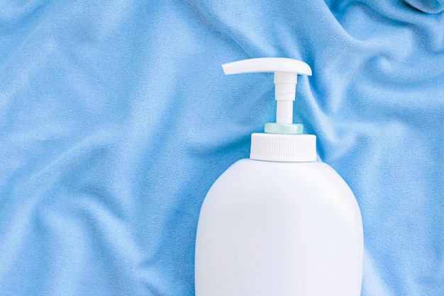 Blank label bottle of antibacterial liquid soap and hand sanitizer mockup on blue silk hygiene product and health care