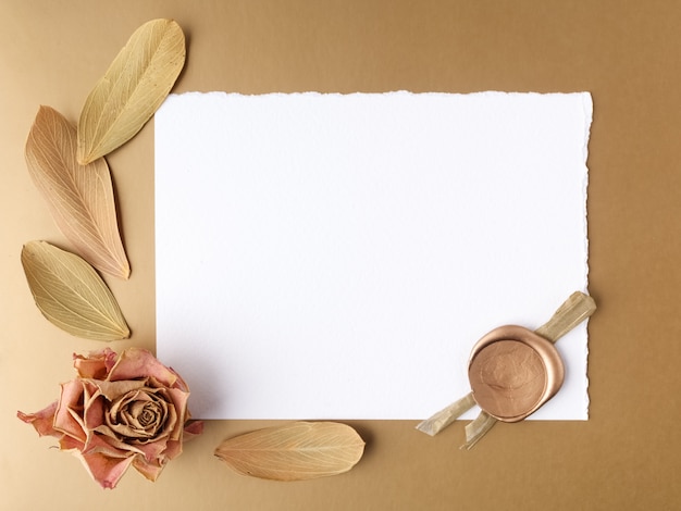 Blank letter and dried roses on a golden background