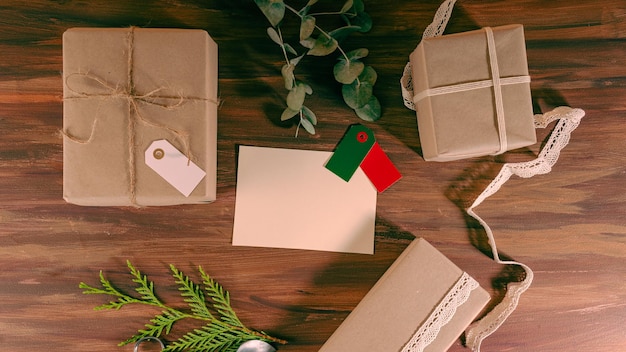 Blank letter and labels for mock up with kraft gift boxes over
a wood background. aerial view