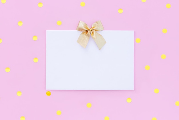 Blank letterhead greeting card with gold sequins on pastel pink background with place for text