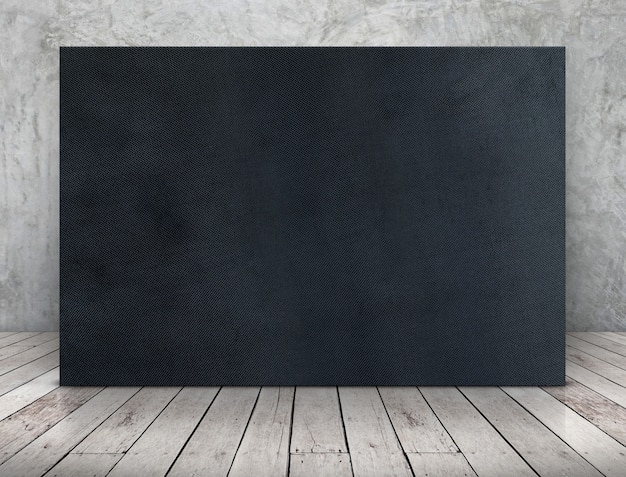 Photo blank long black fabric canvas frame leaning at concrete wall on wooden plank floor