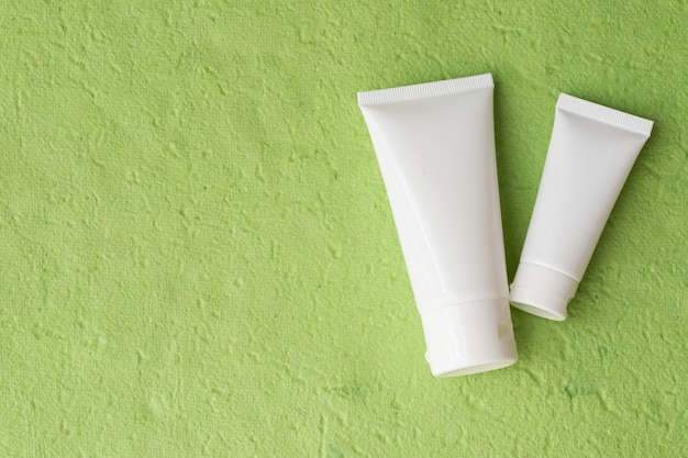 Blank lotion packaging on green.