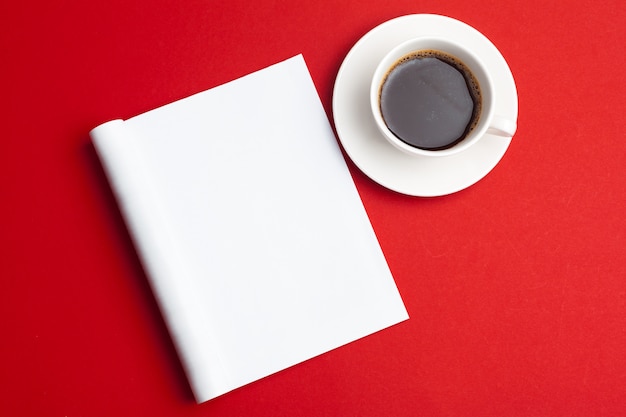 blank magazine and cup of coffee on a red background