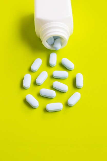 Blank medicinal bottle with pills on the floor