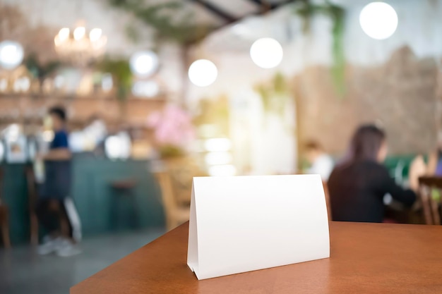 Photo blank menu frame label mockup menu frame mockup n wooden table in bar restaurant stand for booklet with white sheet of acrylic paper tent card