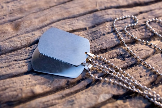 Photo blank military dog tags on abandoned metal plate memories and sacrifices concept still life disc necklace image for ecommerce online selling social media jewelry sale