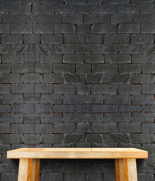 黒いレンガの壁の脚の空のモダンな木製のテーブル