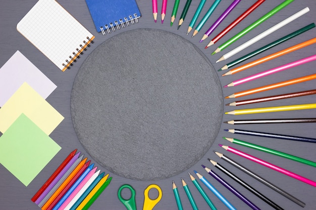 Blank note paper notepads bright colored pencils scissors with round chalk board