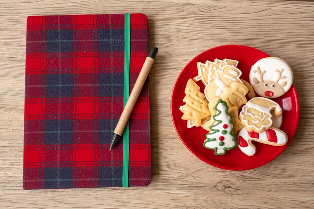 Blank notebook, Christmas cookies and pen on wood table. Xmas, Happy New Year, Goals, Resolution, To do list, Strategy and Plan concept