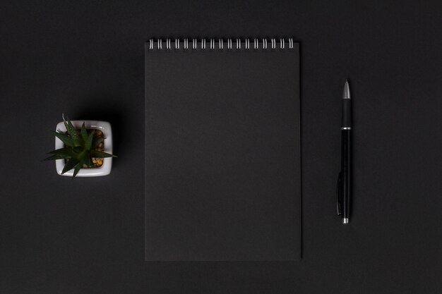 Blank notebook on dark background copy space top view