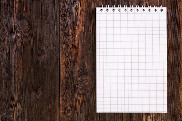 Blank notebook on a dark wooden background, copy space