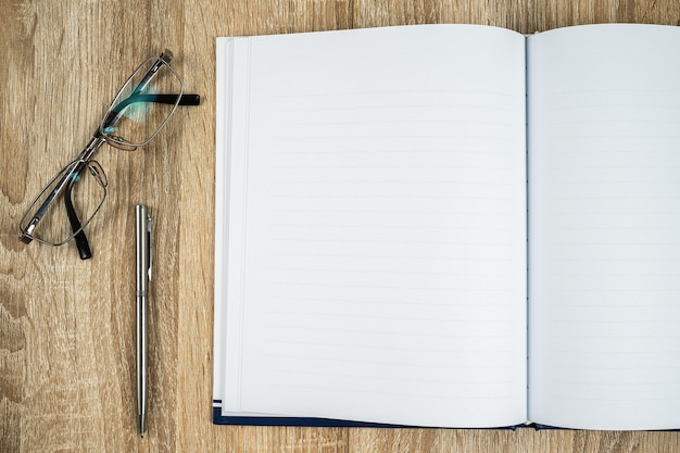 Blank notebook diary with silver pen and glasses