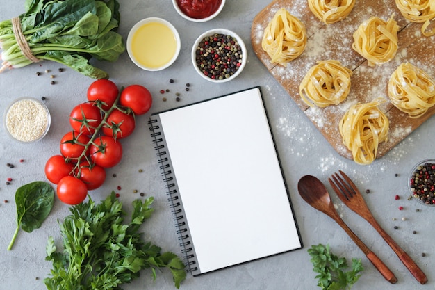 Foto ingredienti freschi del taccuino in bianco per produrre pasta italiana